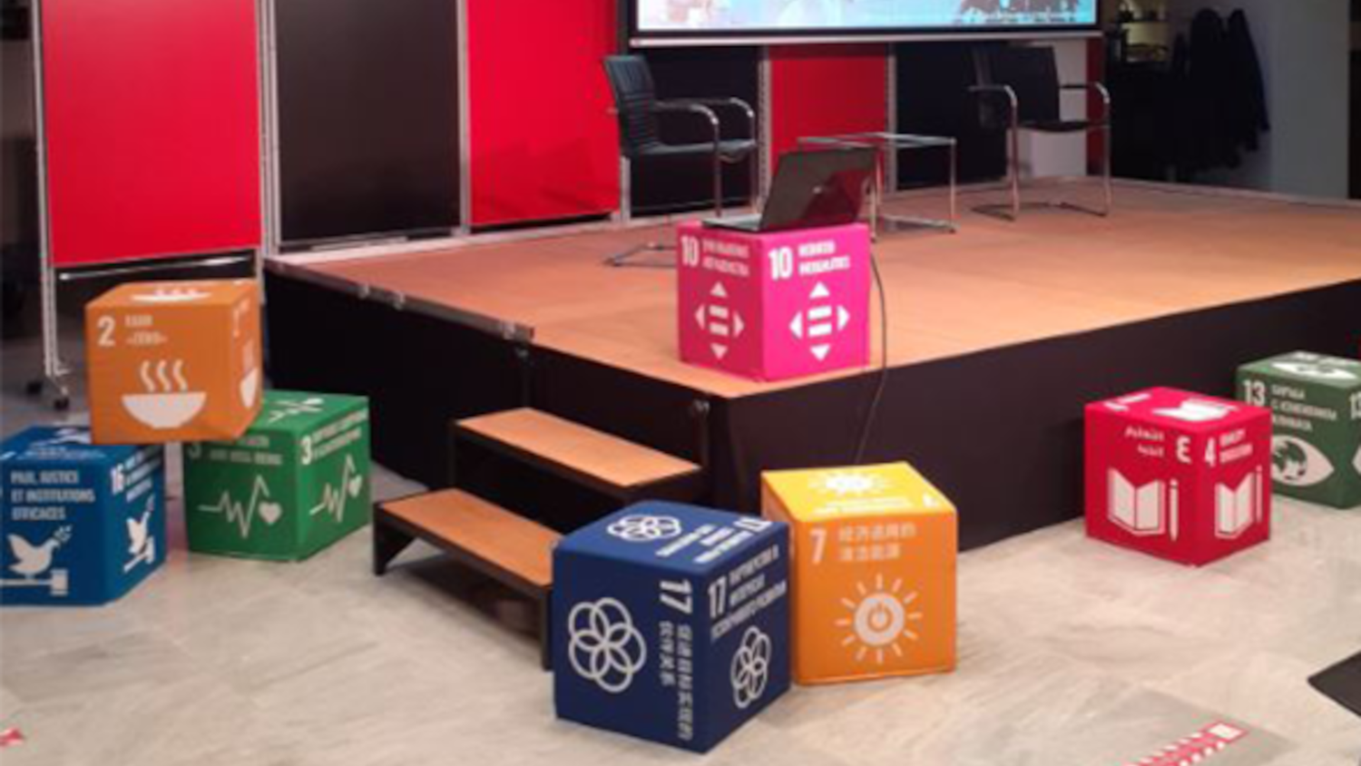 Typical Swiss scene showing a meadow, village, lake and mountains, with the Swiss cross logo surrounded by dots and '2030 Agenda' underneath.